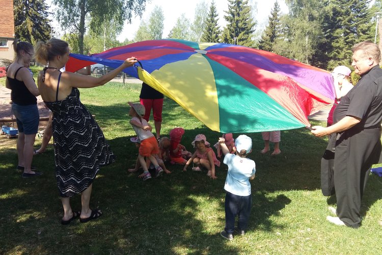 Lapset leikkivarjon alla perhekerhossa