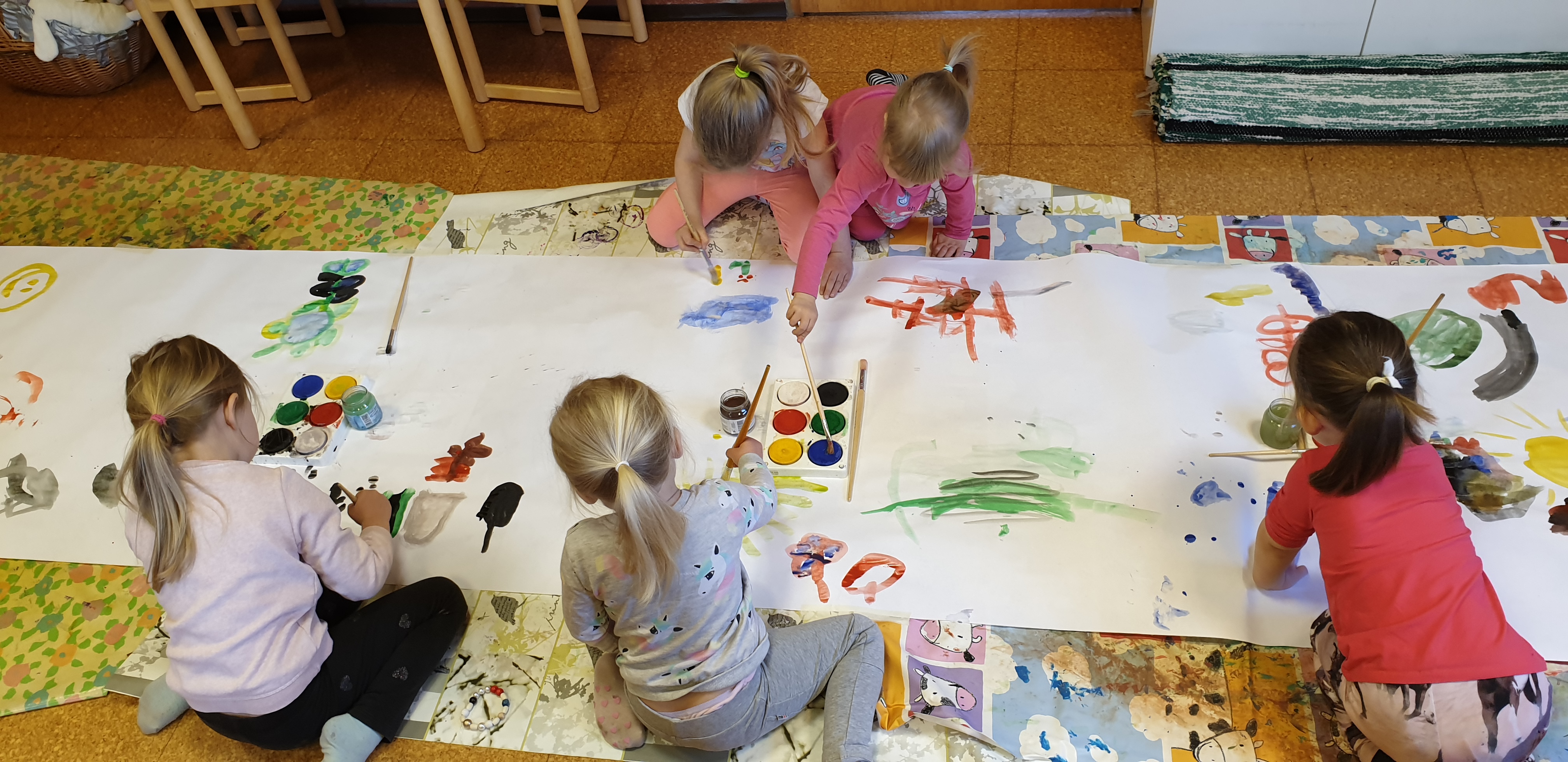 Perhekerhon lapset maalaamassa yhteistä taideteosta keväällä 2019.