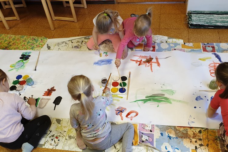 Perhekerhon lapset maalaamassa yhteistä taideteosta keväällä 2019.