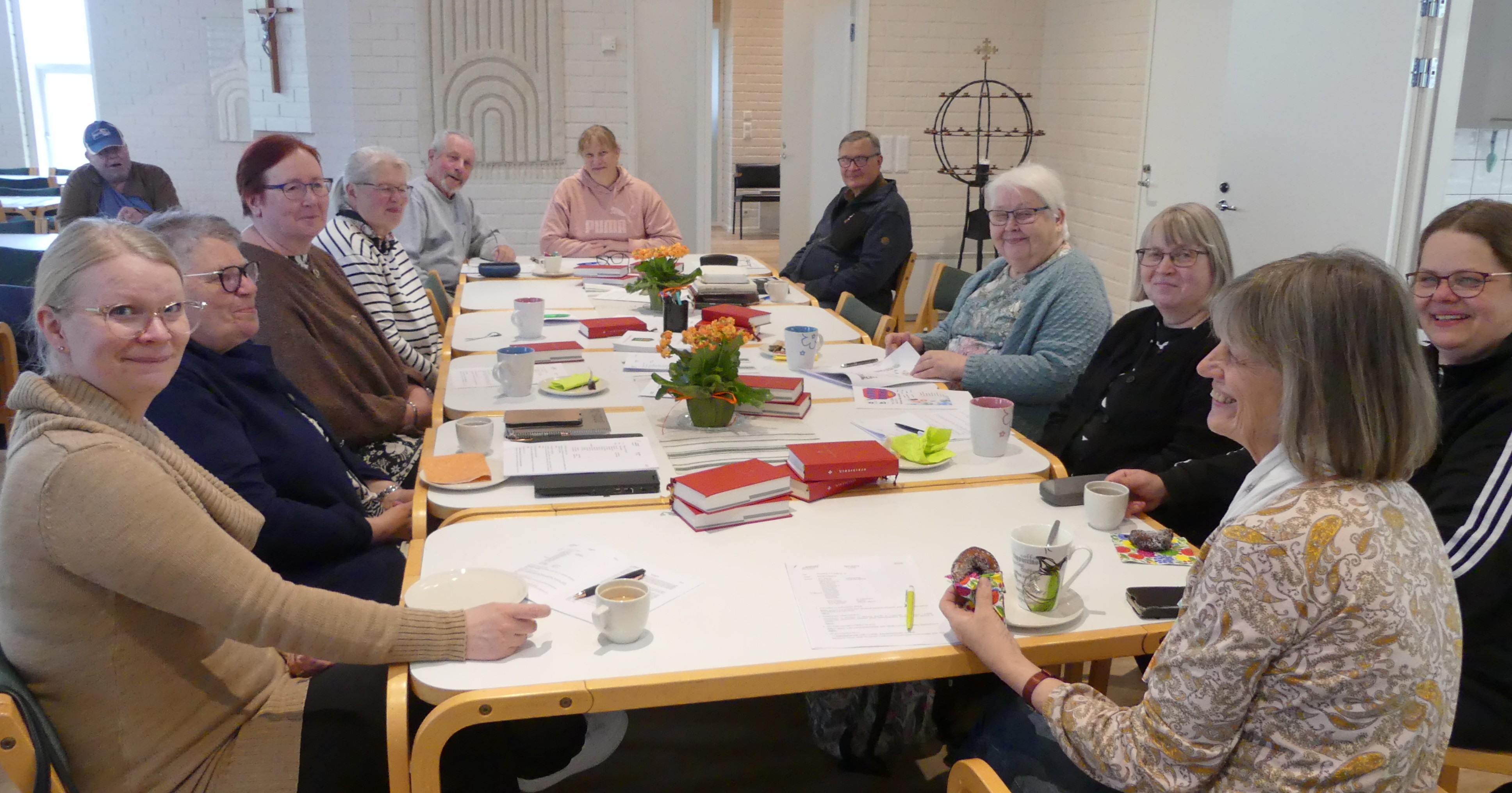 Palvelutiimin 12 edustajaa istumassa kokouksessa 11.5.2028 seurakuntakeskuksessa.